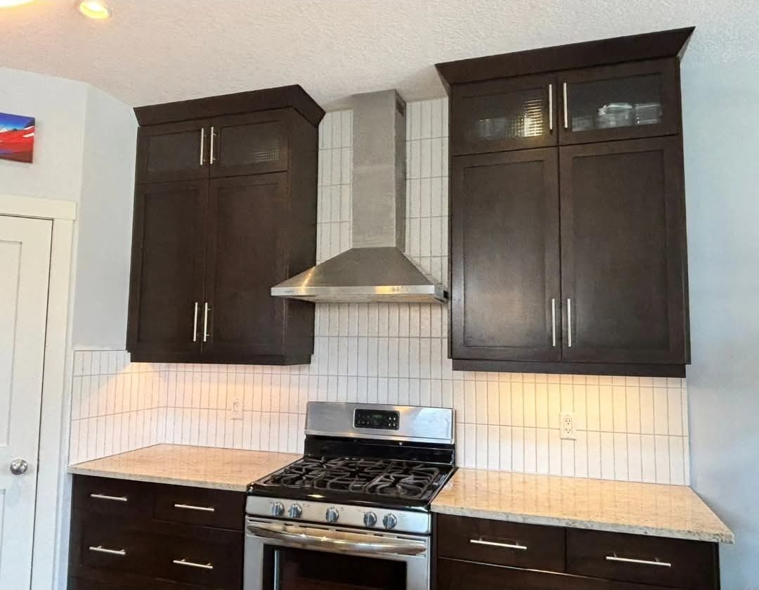 Bergen Renovation — Kitchen with dark cabinets, hood & tile backsplash