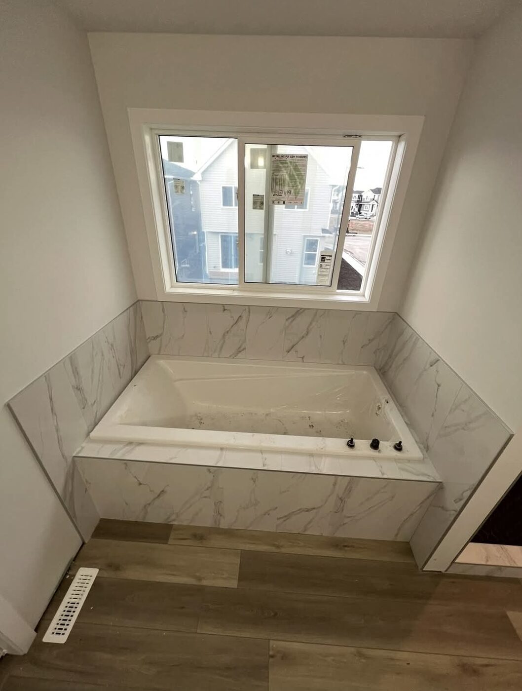 Ceramic Service Professional — Drop-in soaker tub with marble-look tile surround