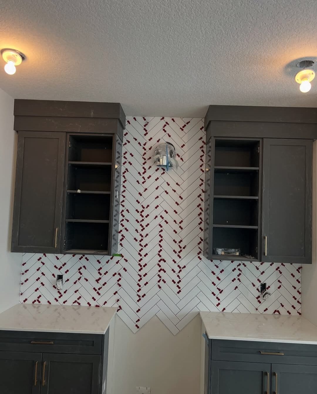 Ceramic Service Professional — Kitchen backsplash in white herringbone tile with accent pattern