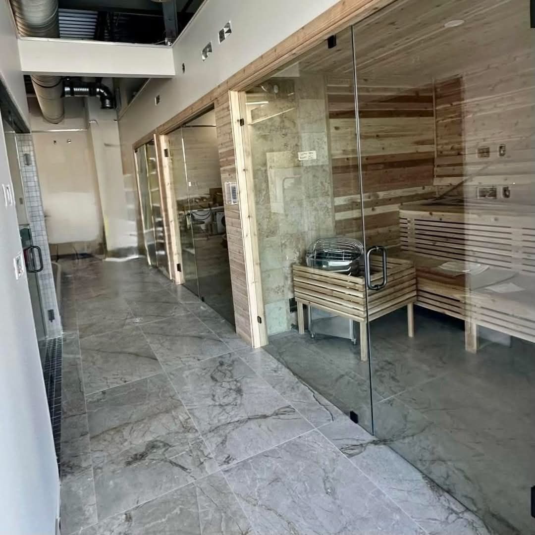Gosur Development Inc. — Commercial spa hallway with glass-front cedar sauna rooms