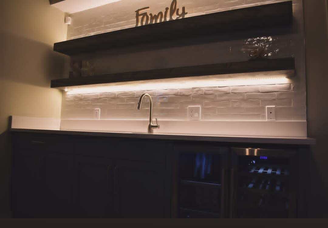 Harvest Pro Renovations — Basement wet bar with floating shelves and beverage fridge