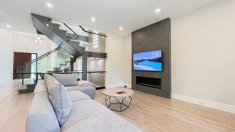 Merit Homes — Living room with feature wall and staircase