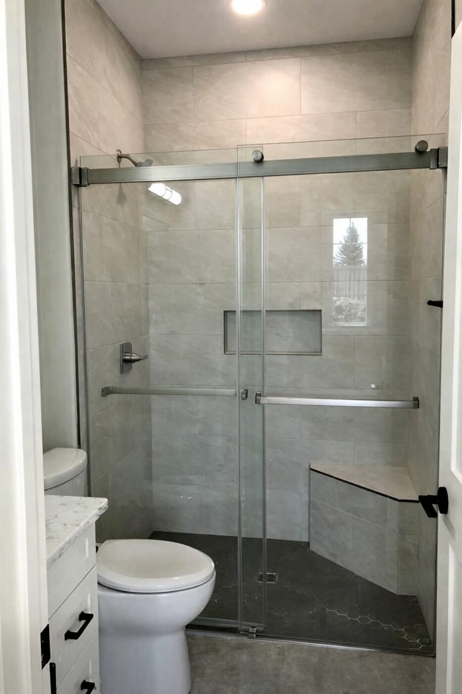 Genica Custom Builders — Tiled walk-in shower with glass sliding doors